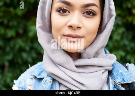 London, UK, England, Portrait of a beautiful muslim girl wearing hijab looking at camera, muslim university student Stock Photo