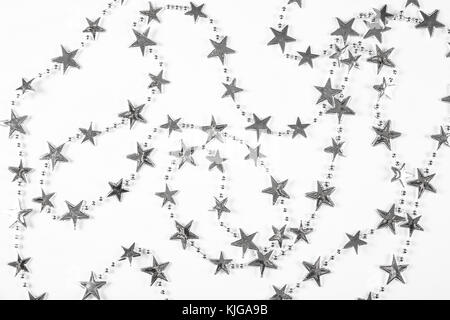 Christmas background with silver stars decorations on white. Simple Christmas composition with copy space Stock Photo