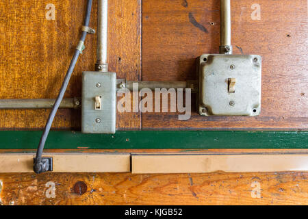 Two vintage light switches on a wooden wall Stock Photo