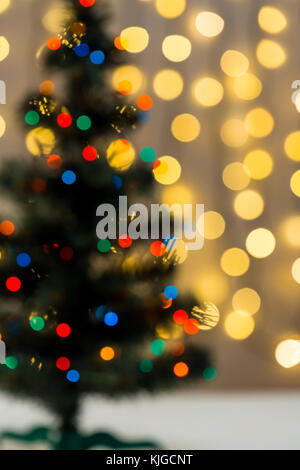 Gold Christmas background of de-focused lights garland with decorated tree Stock Photo