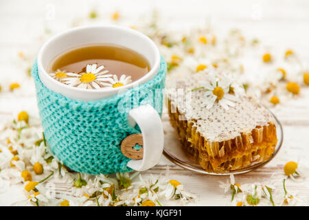 Honeycomb and chamomile tea on white Stock Photo