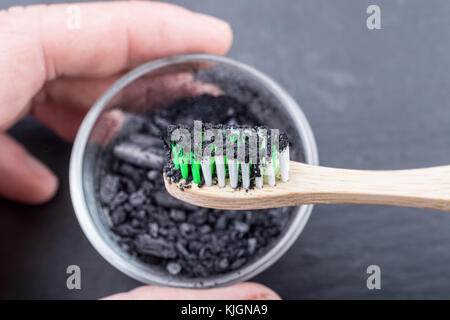 Charcoal on a toothbrush to whiten teeth Stock Photo