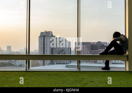 Sad businessman sitting head in hands on the the modern creative Office, dramatic concept Stock Photo