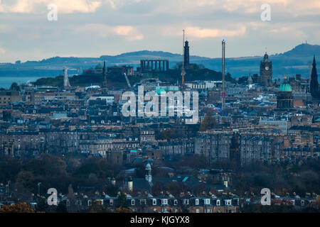 Edinburgh, Scotland, United Kingdom, 23rd November 2017. View over Edinburgh skyline in low Autumn sunlight at dusk looking East to the city centre skyline from Rest and Be Thankful viewpoint with National Monument and Nelson column on Calton Hill visible Stock Photo