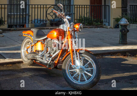 Orange Harley-Davidson motorcycle parked on a street in New York City Stock Photo