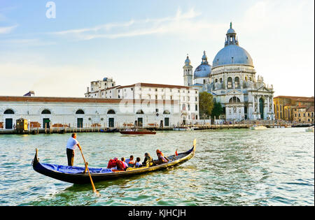 View of the Basilica of Saint Mary of Health with Gondolas punted by gondoliers on the Grand Canal in Venice. Stock Photo