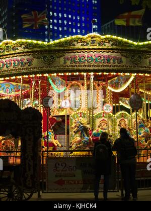 Colourful Carousel with the silhouette of two people in the night. Southbank, London, England, United Kingdom. Stock Photo