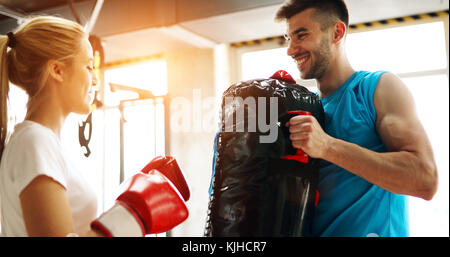 Picture of woman wearing boxing gloves and her trainer Stock Photo