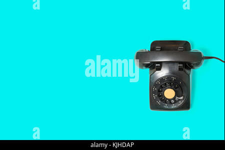 Antique old rotary dial telephone on turquoise background Stock Photo