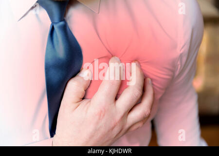 Businessman has a heart attack during stressful day at office Stock Photo
