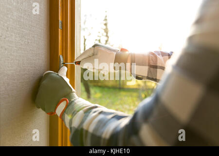 Handyman fixing the window with screwdriver Stock Photo
