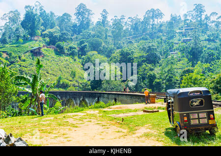 DAMODARA, SRI LANKA - DECEMBER 1, 2016: The tuk tuk taxi next to the Nine Arch Bridge, located in green mountains, on December 1 in Damodara, Sri Lank Stock Photo