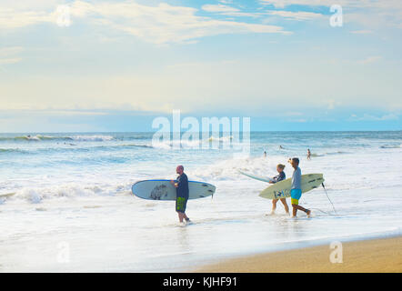 CANGGU, BALI ISLAND, INDONESIA - JAN 19, 2017: Group of surfers going to surf in the beach. Bali island is one of the worlds best surfing destinations Stock Photo