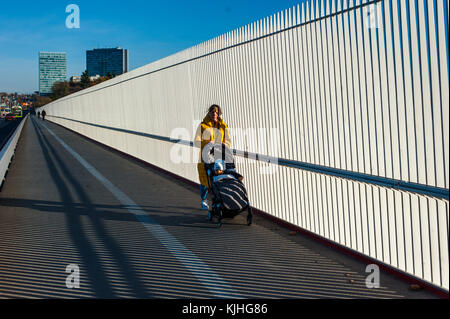 Young woman walking on the bridge with a stroller, Luxembourg City Stock Photo