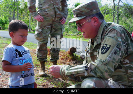 Brig. Gen. Jose J. Reyes, Puerto Rico Deputy Adjutant General and the dual commander of Joint Task Force Puerto Rico, takes some time from delivering food and supplies to Barranquita, Puerto Rico residents to play with a small child Nov. 13, 2017. (U.S. Air National Guard photo by Maj. Patrick Cordova/Released) Stock Photo