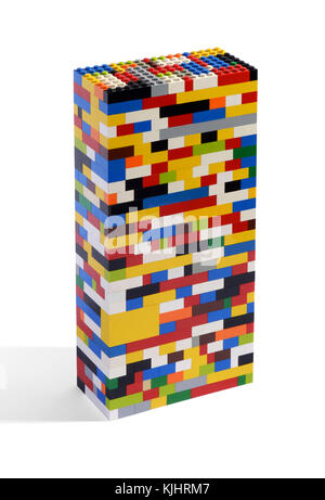 Close-up studio shot of a plastic toy tower made of colorful building bricks or blocks with shadow on white background for copy space Stock Photo