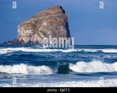 Haystack (Kiawanda) Rock with waves on beach at Cape Kiwanda, Pacific City, Oregon. Stock Photo