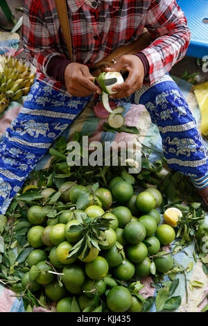 Shopkeeper peeling oranges at a Battambang market. Cambodia. Stock Photo