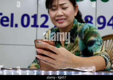 Shopkeeper using a cell phone. Battambang.  Cambodia. Stock Photo