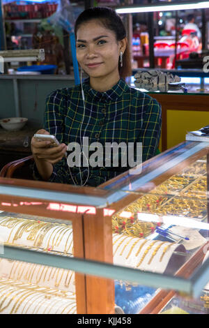 Shopkeeper using a cell phone. Battambang.  Cambodia. Stock Photo