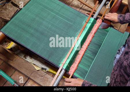 A woman weaves traditional cloth in a loom.  Dalat. Vietnam. Stock Photo