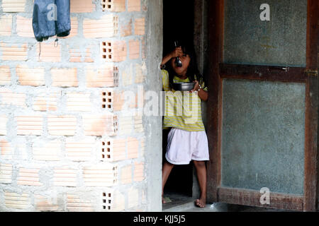 Bahnar (Ba Na) ethnic group.  Young girl eating.  Kon Tum. Vietnam. Stock Photo