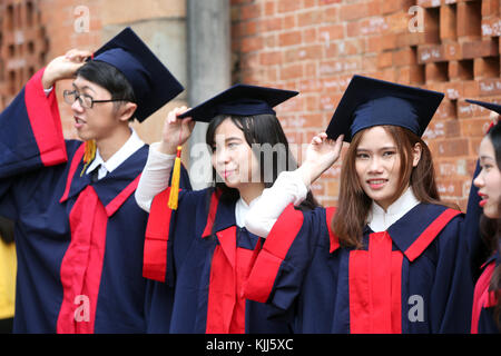 Group of Young Asian university students wearing cap and gown.  Ho Chi Minh City.  Vietnam. Stock Photo