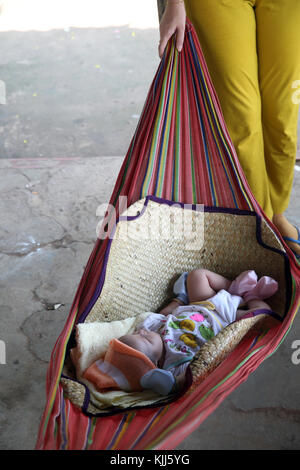 Mother with baby sleeping in Hammock.  Thay Ninh. Vietnam. Stock Photo