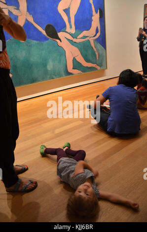 Child lying on the floor in front of 'Dance' by Henri Matisse in MoMA New York City. Stock Photo