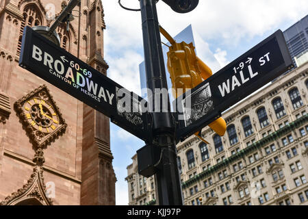 Broadway and Wall Street intersection in Manhattan with Trinity Church in the background. Stock Photo
