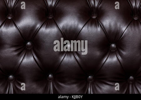 Closeup shot of dark brown leather texture with buttons. Furniture texture Stock Photo