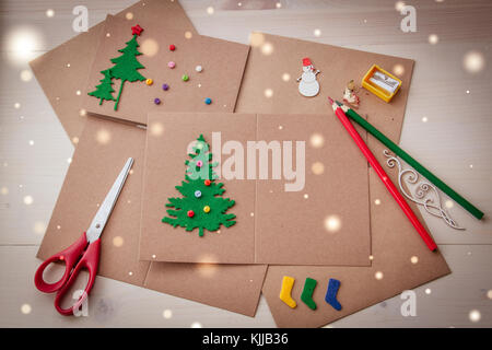 Signing Handmade Christmas cards. Felt, scissors, buttons, Christmas-tree, scrapping. Flat lay Stock Photo