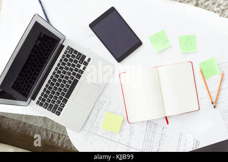 Office workplace with laptop, notebook, drawings, tablet computer on desk Stock Photo