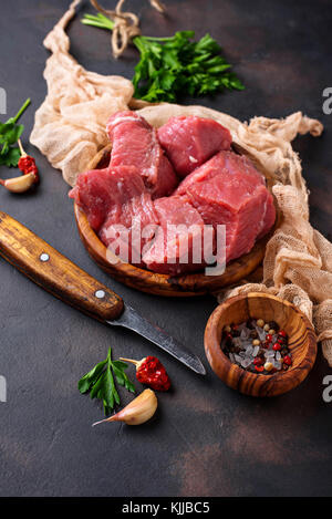 Raw chopped meat with spices on rusty background. Selective focus Stock Photo