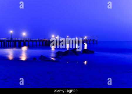 Pier and rocks on the beach. View from Coney Island Beach, Brooklyn, New York. Stock Photo