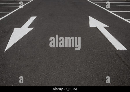 white arrows on black asphalt road background Stock Photo