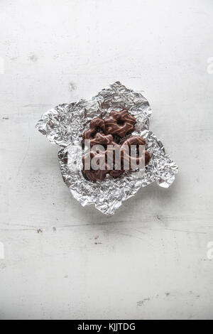 Gingerbread. Chocolate gingerbread in aluminium foil on table. Stock Photo