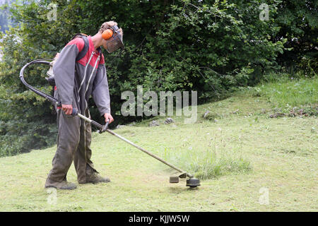 Gardner cutting grass.  France. Stock Photo