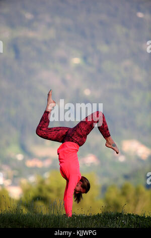 Woman doing yoga and meditation outside. Handstand with Splits. Stock Photo
