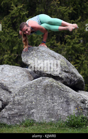 Woman practicing yoga on rocks. Les Contamines. France. Stock Photo