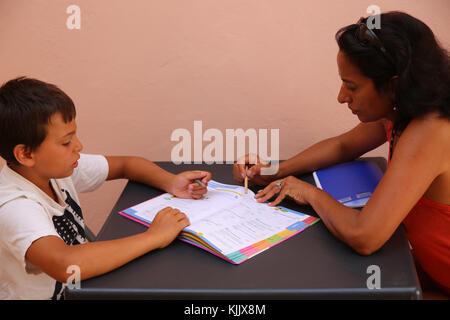 Boy doing homework with his mother. Stock Photo