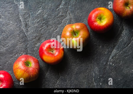 Ripe autumn apples red and yellow on a black stone background from slate. Harvesting. Vitamins are good for health. Copy space. Stock Photo