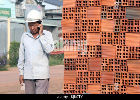 Construction site. Worker using phone.  Thay Ninh. Vietnam. Stock Photo
