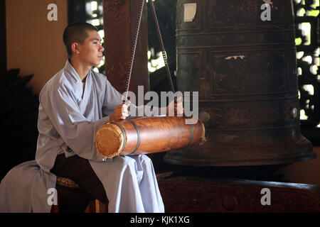 Linh An buddhist pagoda.  Young monk ringing bell in monastery.  Dalat. Vietnam. Stock Photo
