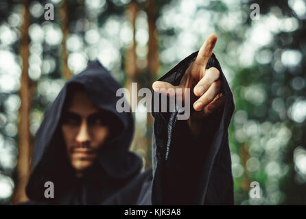 the black monk pointing his finger in the woods Stock Photo