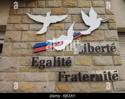 The words Liberté, égalité, fraternité (lit. liberty, equality, fraternity) and peace doves attached to a wall of the town hall in Crozon (France). It is the motto of the current French Republic and was the slogan of the French Revolution of 1789. Photo: Jens Kalaene/dpa-Zentralbild/ZB | usage worldwide Stock Photo