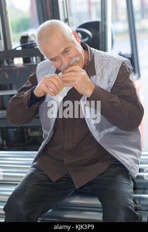 worker eating a bread Stock Photo