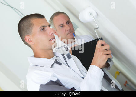 painter with apprentice and client Stock Photo