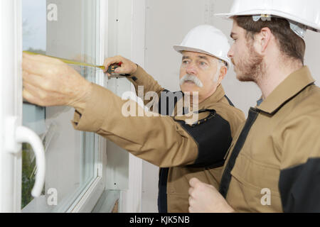 workers are using tape measure the window in construction site Stock Photo