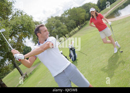 male golf instructor teaching female golf player Stock Photo